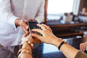 Wall Mural - Woman paying by credit card at cafe