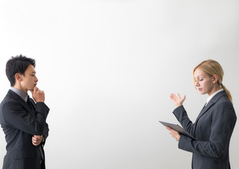 Two business persons in front of white blank space.