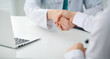 © rogerphoto - Doctor and patient shaking hands, close-up.  Physician talking about medical examination results. Medicine, healthcare and trust concept