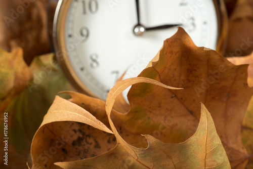 Zdjęcie XXL Liście i zegar zmiany czasu na czas zimowy