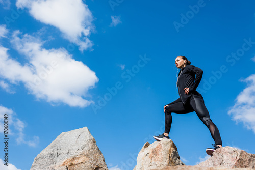 Plakat kobieta lekkoatletycznego stojącego na skałach
