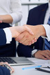 © rogerphoto - Business handshake at meeting or negotiation in the office, close-up. Partners are satisfied because signing contract or financial papers