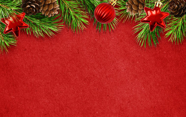 holiday red background with christmas tree twigs, cones, balls