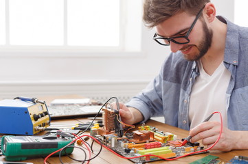 Poster - Engineer checking motherboard with multimeter