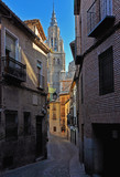 Fototapeta Uliczki - Narrow street opening to a high cathedral
