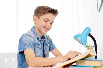 Wall Mural - student boy reading book at home table
