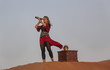 lady pirate in a desert with a wooden treasure trunk