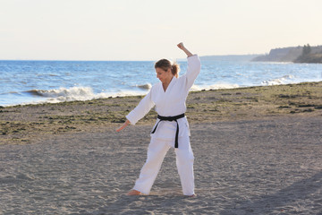 Wall Mural - Young woman practicing karate outdoors