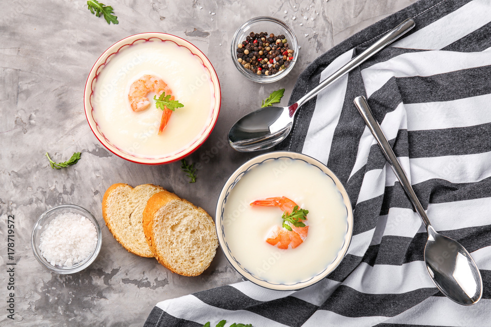 Tasty cream soup with shrimps in bowls on table