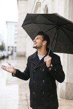 Handsome Man With Umbrella Smiling In The Rain