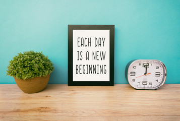 Wall Mural - Motivational and inspirational life quotes - Each day is a new beginning. Frame and plant with teal blue background, retro style.
