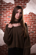 © vpavlyuk - Model test of fabulous brunette model with long hair, wears oversize sweater, posing on a brick wall background