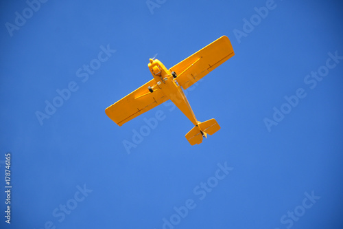 Plakat Mały samolot lata nad niebieskim niebem Huesca