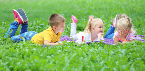 Wall Mural - Adorable little children lying on blanket in park