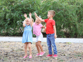 Wall Mural - Adorable little children catching soap bubbles outdoors