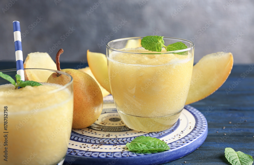 Plate with glass of fresh melon smoothie on table