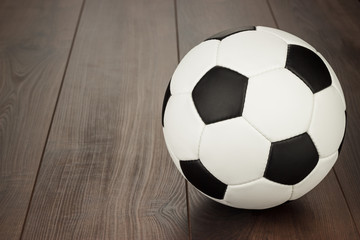 Wall Mural - soccer ball on the brown wooden table