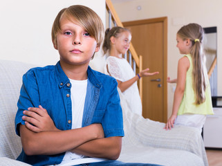 Wall Mural - Two girls talking and sulky boy sitting separately at home