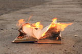 Fototapeta Tęcza - book with burning pages on a concrete surface