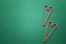 Green Christmas Background With Red Candy Canes. Copy Space. Christmas Minimalism.