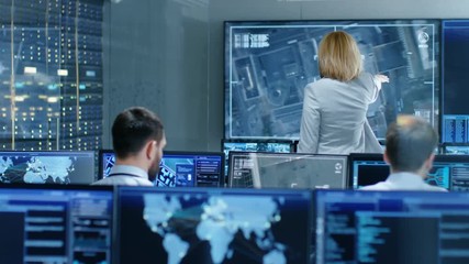 Leinwandbilder - In the Government Surveillance Facility Team of Officers Organize Interception Plan with Help of Satellite Navigation. Big Screen Shows Top Down Images of the Target. 
