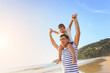 © SKT Studio - Father playing with his son on the beach at the sunset time