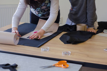 Wall Mural - seamstress at work on the table, tailor woman work in studio with clothes 