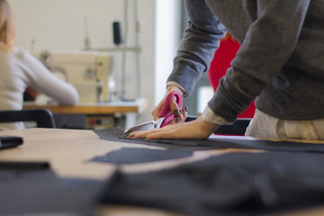 Wall Mural - seamstress at work on the table, tailor woman work in studio with clothes 