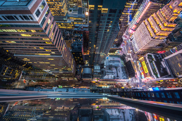 bird's eye view of manhattan, looking down at people and yellow taxi cabs going down 5th avenue.