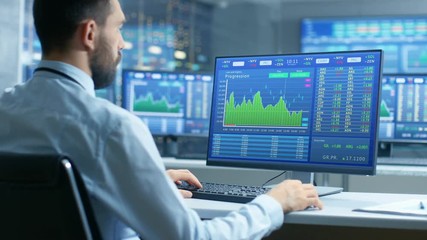 Aufkleber - Over the Shoulder View of Stock Market Trader Working on a Computer Showing Stock Ticker Numbers and Graphs.  Shot on RED EPIC-W 8K Helium Cinema Camera.