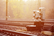 Photo Of A Fragment Of A Railway Track With A Small Traffic Light In Rainy Weather