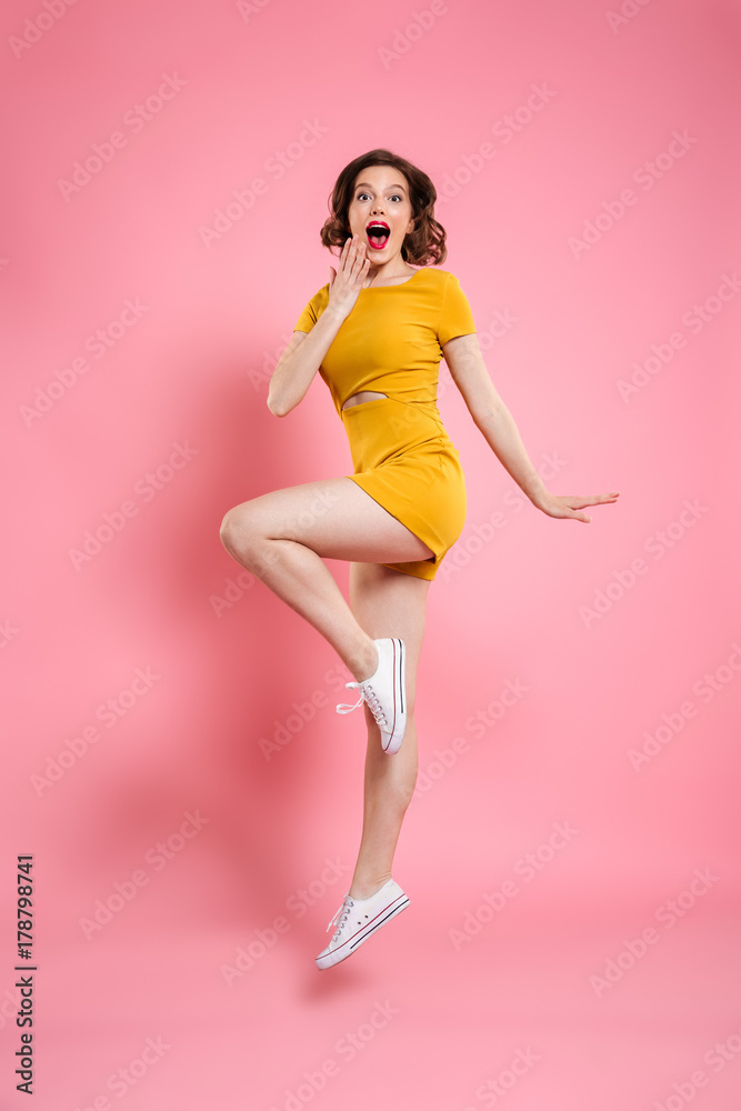 Full length portrait of happy exited pretty girl in elegant yellow ...
