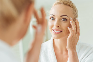 beautiful woman looking at mirror