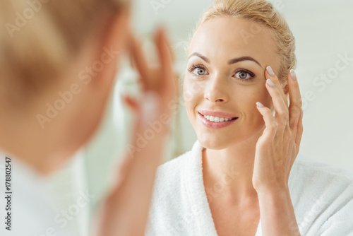 Fotomural beautiful woman looking at mirror