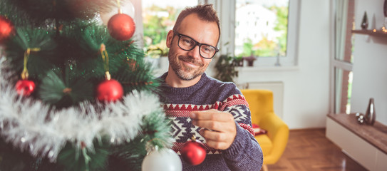 Happy men decorating Christmas tree