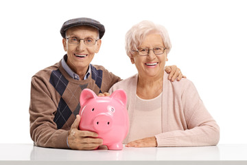 Sticker - Senior couple with a piggybank seated at a table