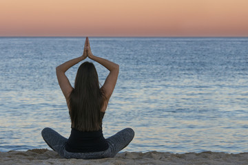 Wall Mural - woman doing yoga and meditation in front of the sea