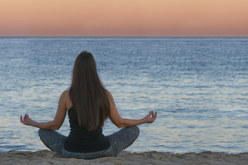 Wall Mural - woman doing yoga and meditation in front of the sea