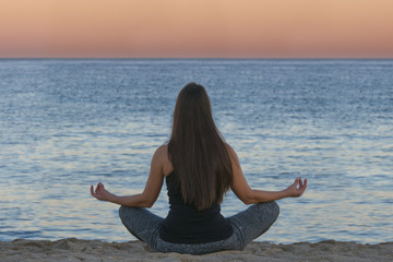 Wall Mural - woman doing yoga and meditation in front of the sea
