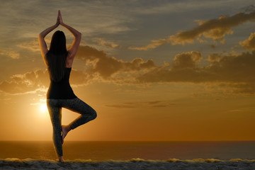 Wall Mural - woman doing yoga and meditation in front of the sea