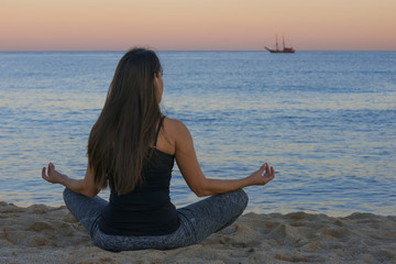 Wall Mural - woman doing yoga and meditation in front of the sea