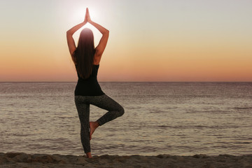 Wall Mural - woman doing yoga and meditation in front of the sea