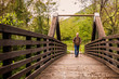 © Franco Nadalin - hike man with backpack walking in forest nature outdors bridge.