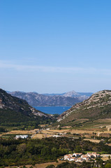 Corsica, 28/08/2017: vista panoramica del paesaggio selvaggio dell'Alta Corsica con le montagne circondate da colline verdi, vigneti e campi di grano