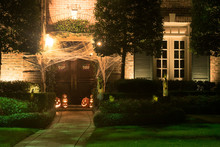 The House Is Decorated For Halloween: The Entrance To The House Is Tightened With Cobwebs, Pumpkins With Carved Mugs And Glowing From Within. Night