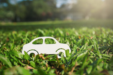 Paper cut of car on green grass background, earth day eco green energy concept with copy space, spring time, background and banner