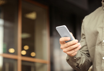 Young handsome man using his mobile phone outdoors