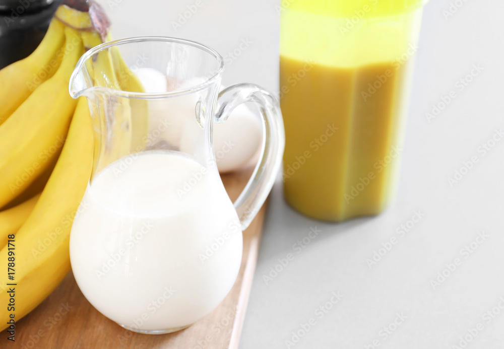 Glass pitcher of milk on table