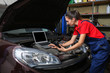 © Africa Studio - Young female mechanic with laptop repairing car in body shop