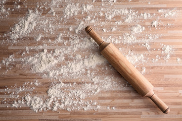 Poster - Scattered flour and rolling pin on wooden background